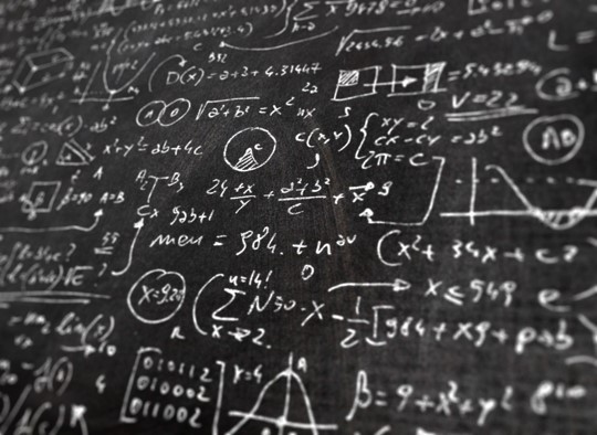 Mathematical equations (white chalk on a black chalkboard)